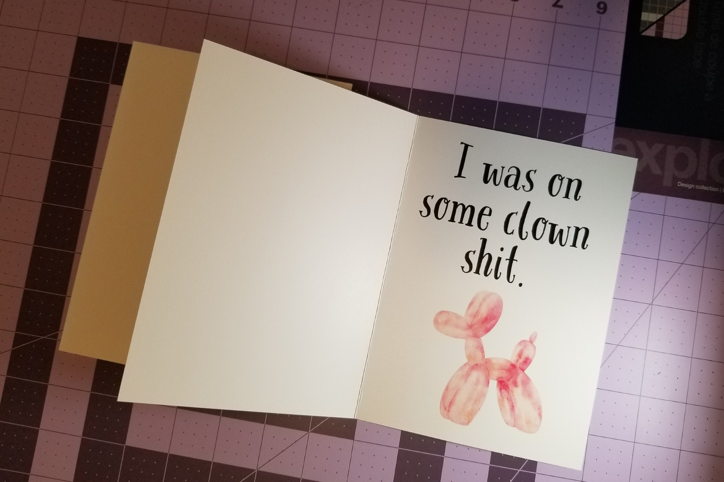 Card with balloon dog illustration and text on a cutting mat.